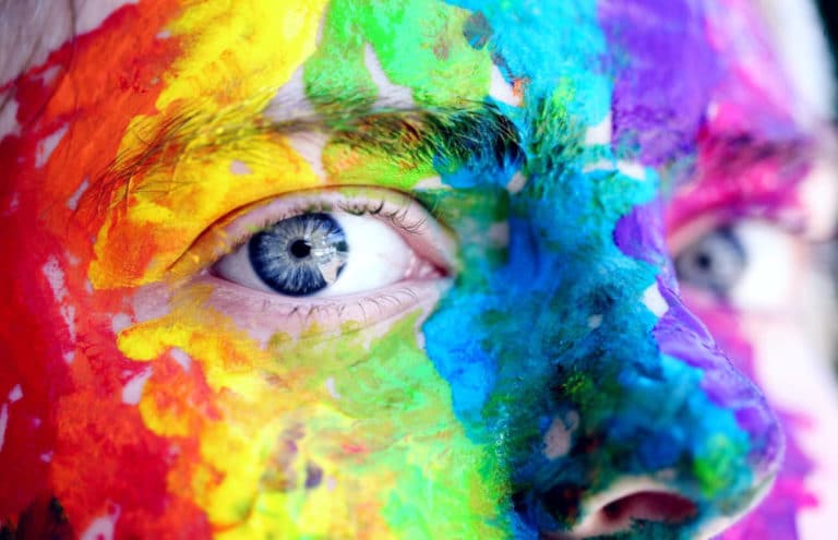 Picture of face with many different colors of paint on it
